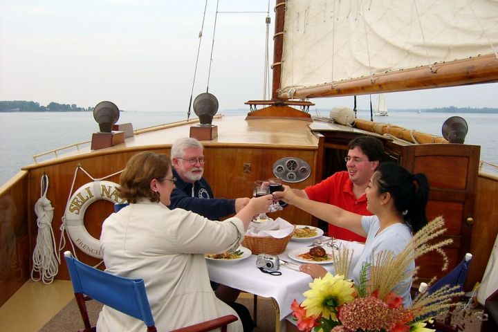 group having dinner and toasting on the sail boat