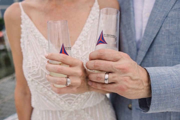 Couple in wedding attire holding champagne flutes.