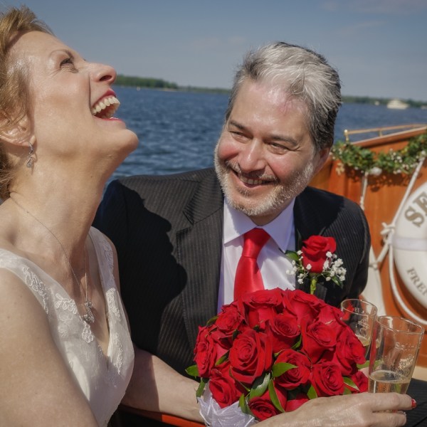 Find love and happiness once again with a nautical wedding or elopement aboard Sail Selina in St. Michaels, MD - Capture the passion and serenity of a couple in love, just like this couple with the stunning red rose bouquet - Book your Sail Selina boat wedding now!