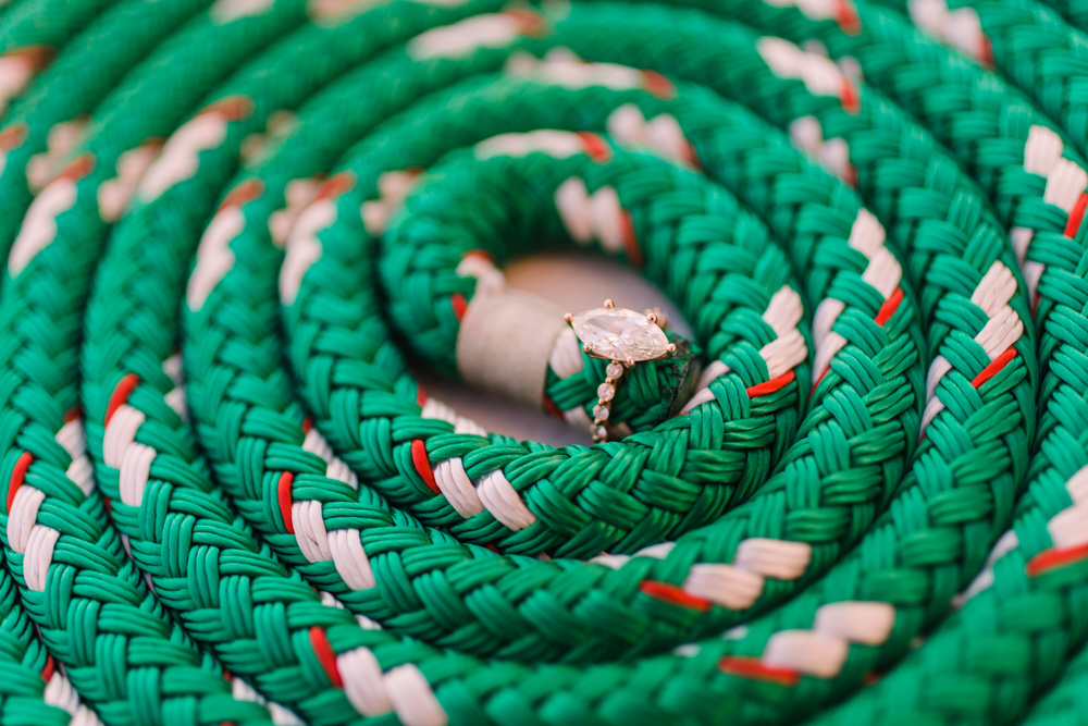 A diamond ring nestled in coiled green, white, and red rope.