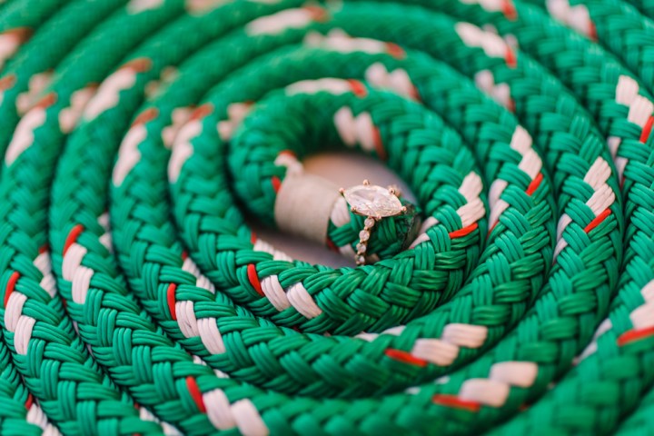 A diamond ring nestled in coiled green, white, and red rope.