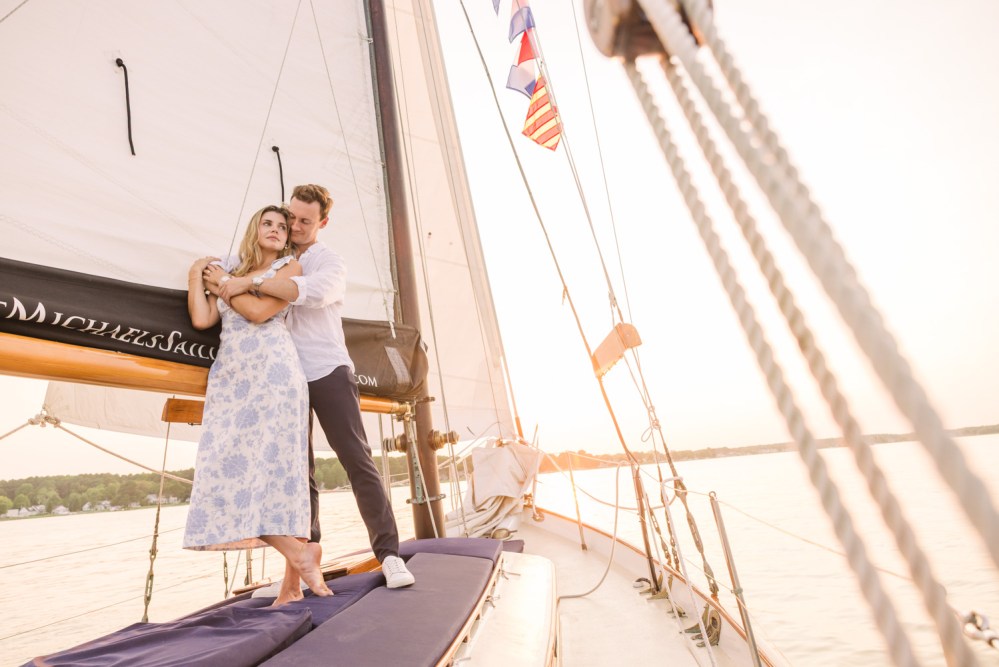 Couple embracing on a sailboat at sunset.
