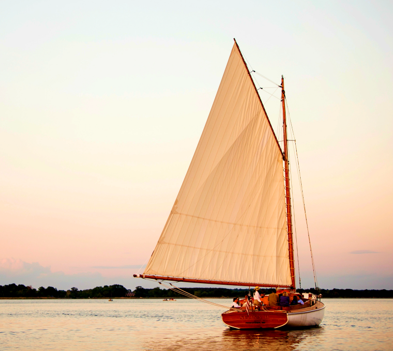 "Experience the enchanting beauty of Sail Selina during an early evening sail on the Chesapeake Bay in St. Michaels, MD - This mesmerizing image captures the warm and alluring colors of the sunset, as Sail Selina glides through the open waters, inviting you to witness the magic of the moment - With our expert crew at the helm, enjoy the calming and rejuvenating atmosphere of an evening sail, as you revel in the stunning views and graceful elegance of Sail Selina's well-maintained boat - Fall in love with the enchanting ambiance of the Chesapeake Bay at dusk, a truly unforgettable experience - Book now and experience a Sail Selina evening sail unlike any other!