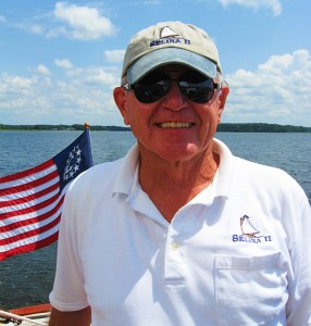 a man holding a fish on a boat in a body of water