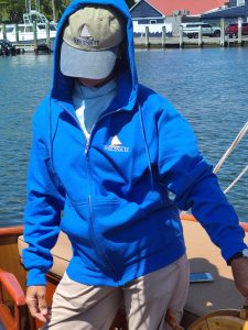 a man wearing a blue hat in front of a body of water
