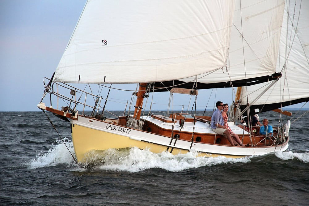 Sailboat named 'Lady Patty' on open water with four people onboard.
