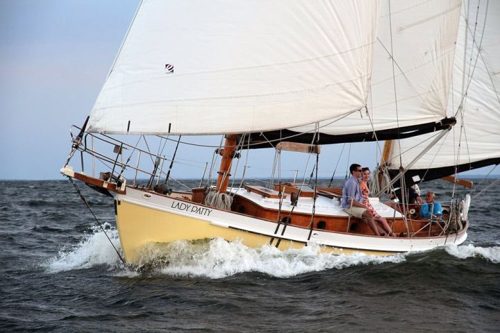 Sailboat named 'Lady Patty' on open water with four people onboard.