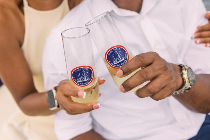 Couple toasting with custom champagne glasses.