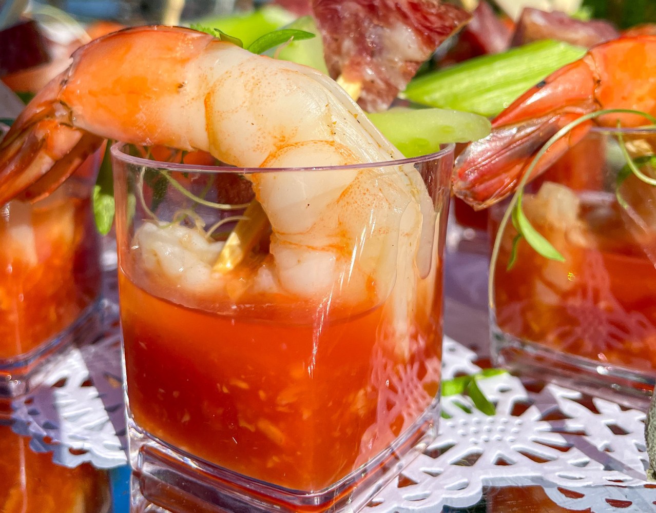 Close-up of shrimp cocktail with sauce in a clear glass.