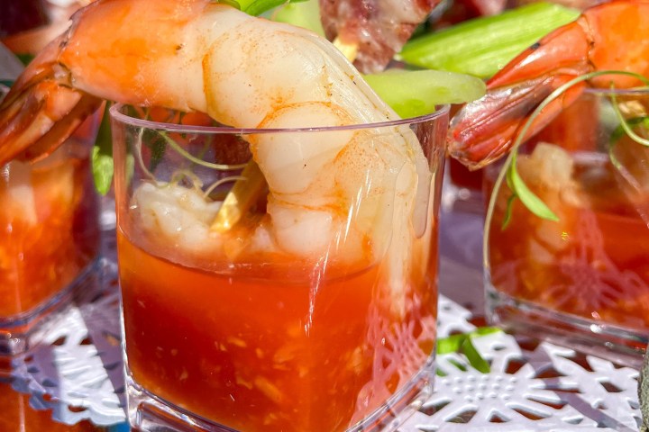 Close-up of shrimp cocktail with sauce in a clear glass.